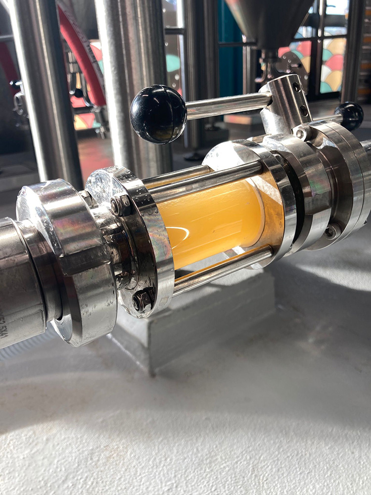 Viseur de contrôle montrant la clarté d'une bière artisanale en cours de transfert dans la brasserie.
